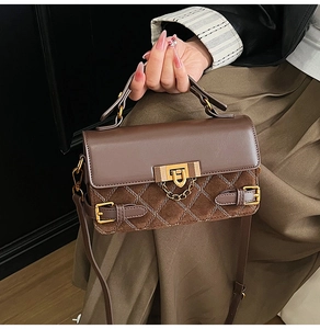 Detail einer Vintage-Handtasche in Braun mit goldenem Schloss und Steppmuster