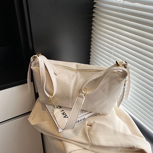 Quilted cream crossbody bag with gold hardware shown in a minimalist aesthetic setting