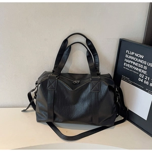 Detail view of large black vintage pillow bag featuring adjustable strap and metal zipper
