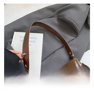 Close-up of golden clasp and mixed leather textures on large commuter shoulder bag