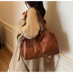 Close-up of vintage brown large capacity pillow bag with textured leather and silver hardware