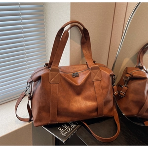 Macro detail of brown leather texture and dual-zipper closure on minimalist travel bag