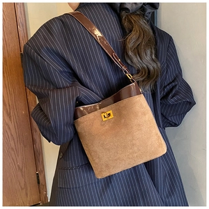 Detail of retro patchwork shoulder bag with gold twist lock and khaki suede finish