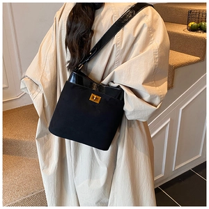 Detail of black contrast texture shoulder bag featuring gold twist lock and wide strap