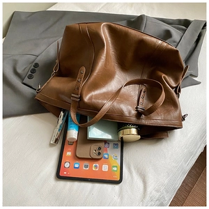 Brown leather tote bag showing large capacity for tablet and cosmetics with star rivets