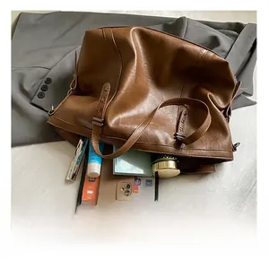 Detail shot showing the spacious interior of this brown leather tote with a tablet and phone