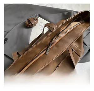 Detailed close-up of premium brown faux leather tote bag with sturdy metal zipper