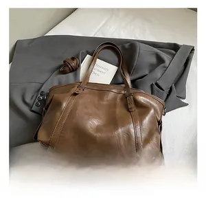 Detail showing high-quality brown tote bag with leather texture and shoulder strap