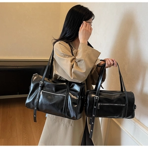 Comparison of large and small black matte Boston bags with silver hardware on a model