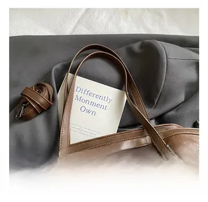Close-up of brown tote bag handle featuring star-shaped rivets and dark hardware details