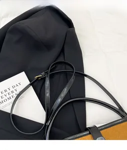 Détail du sac seau matelassé en daim marron avec bandoulière réglable sur veste
