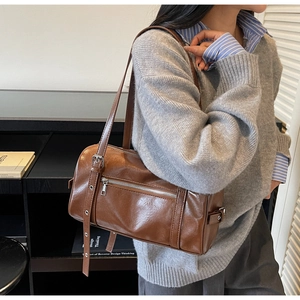 Detail view of the vintage brown Boston bag with smooth leather finish and adjustable strap