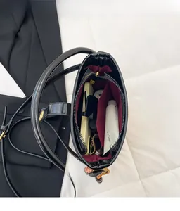 Vue de dessus du sac seau noir brillant spacieux avec doublure rouge foncé et poche