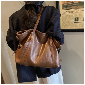 Brown vintage leather tote bag detail with star rivets and long shoulder strap