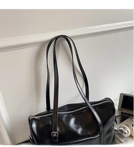 Detail of black Boston bag with dual handles and metal zipper in office setting