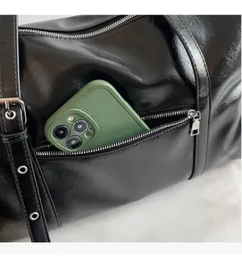 Close-up of a side zipper pocket on a black Boston bag showing phone storage capacity