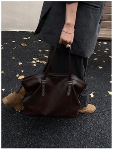 Close-up of vintage brown leather tote bag with star studs and double handles