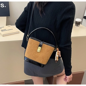 Sac seau en daim marron avec surpiqûres matelassées et style vintage sur mannequin