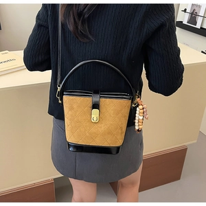Détail du sac seau vintage en daim matelassé avec garniture en cuir et breloque en perles chic