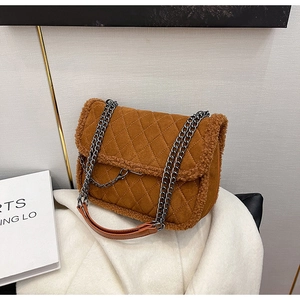Detail of brown suede quilted shoulder bag with white fleece trim and silver chain