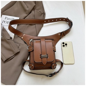 Detailed view of vintage brown pebbled leather waist bag with punk metal hardware and phone