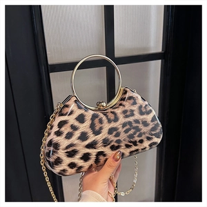 Detail of leopard print clutch featuring a gold ring handle and detachable chain strap