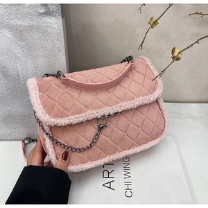 Detail of pink quilted shoulder bag featuring soft faux fur trim and metallic chain