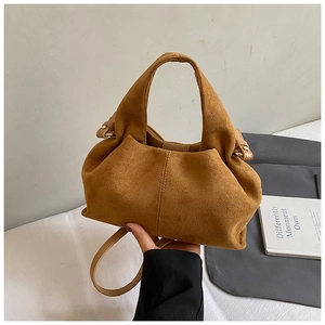 Detail of vintage brown suede bucket bag featuring textured finish and wide handle