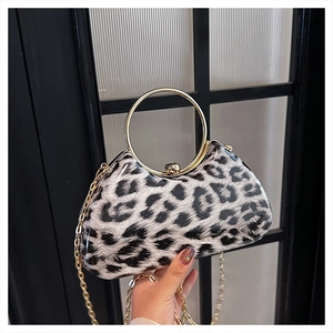 Detail of leopard print clutch with gold circular handle and metal chain strap
