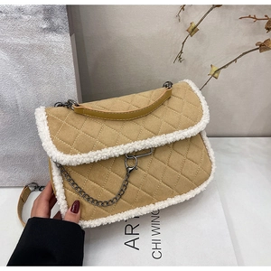 Detail of camel quilted crossbody bag with white faux shearling trim and metal chain