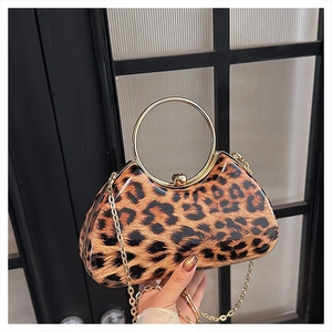 Detail of leopard print clutch featuring a gold circular handle and metallic chain strap