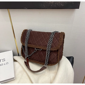 Detail of dark brown quilted shoulder bag with faux shearling trim and metal chain strap