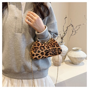 Close-up of leopard print box bag with metallic handles and elegant gold chain strap