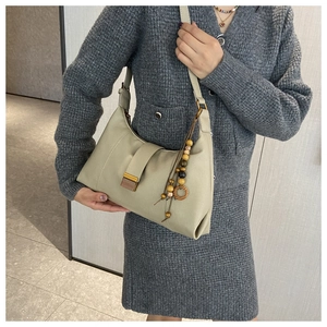 Hobo shoulder bag with vintage metal buckle and wooden beaded tassel detail