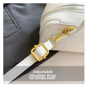 Detail of adjustable strap with gold-tone metal buckle on white leather baguette bag