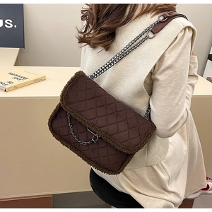 Detail of dark brown quilted underarm bag with plush faux fur trim and chain strap