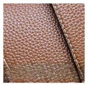 Vue macro du cuir grainé marron avec détails de surpiqûres blanches contrastées durables