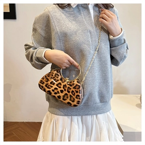 Detail of leopard print box bag with gold metal circular handle and chain strap