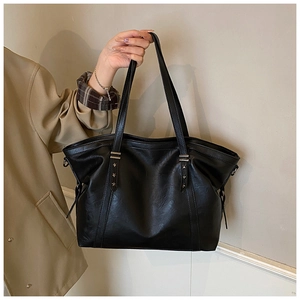 Close-up of black tote bag featuring silver star rivets and premium faux leather texture