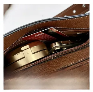Détail de la grande capacité intérieure et de la poche zippée du sac en cuir litchi brun