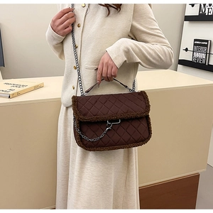 Detail view of quilted dark brown crossbody bag with plush faux fur trim and chain strap