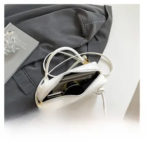 Interior view of the white minimalist baguette bag showing space for phone and makeup