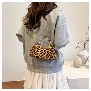Detail of leopard print clutch with golden metal handle and fine chain shoulder strap