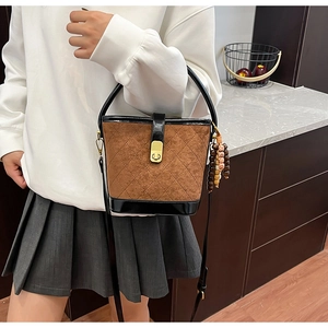 Vue détaillée du sac seau marron givré avec bordure noire et pendentif perlé vintage