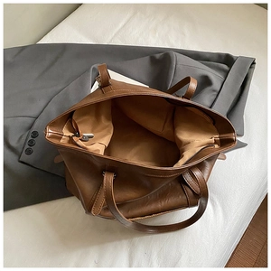Detail of the large capacity interior with zipper pocket in a brown tote bag