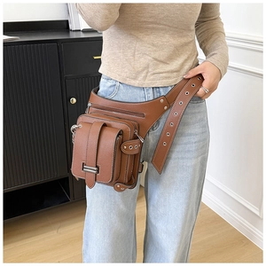 Detail of dark brown lychee leather fanny pack with multiple pockets and metal eyelets