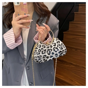 Detailed close-up of leopard print clutch featuring a gold ring handle and chain strap
