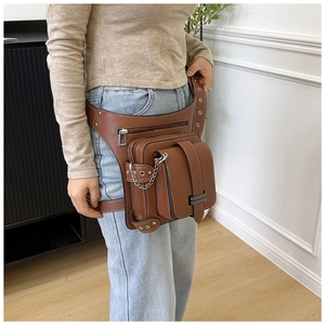 Detail of a brown leather waist bag with lychee texture and silver metal chains