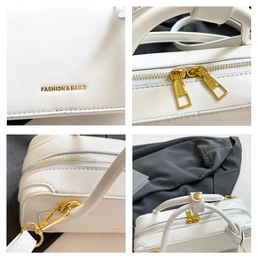 Detail of white baguette bag with gold zippers and Fashion & Bags metal lettering