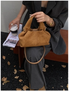 Close-up of brown suede ruched hobo bag with adjustable leather strap for autumn